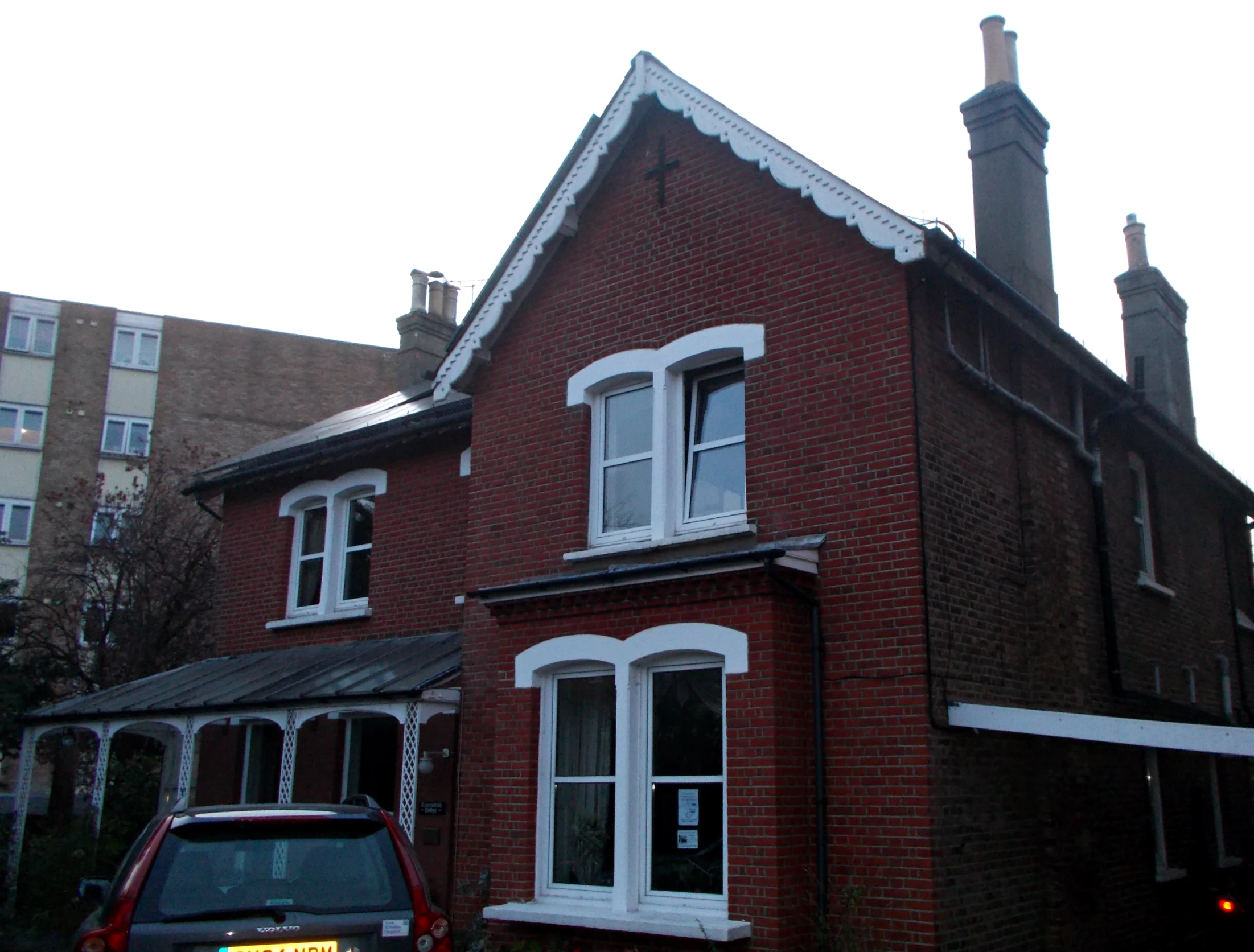 a car parked in front of a red brick house