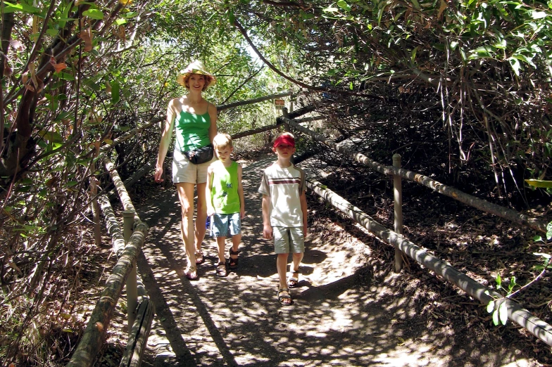 three people and two children walking down a trail