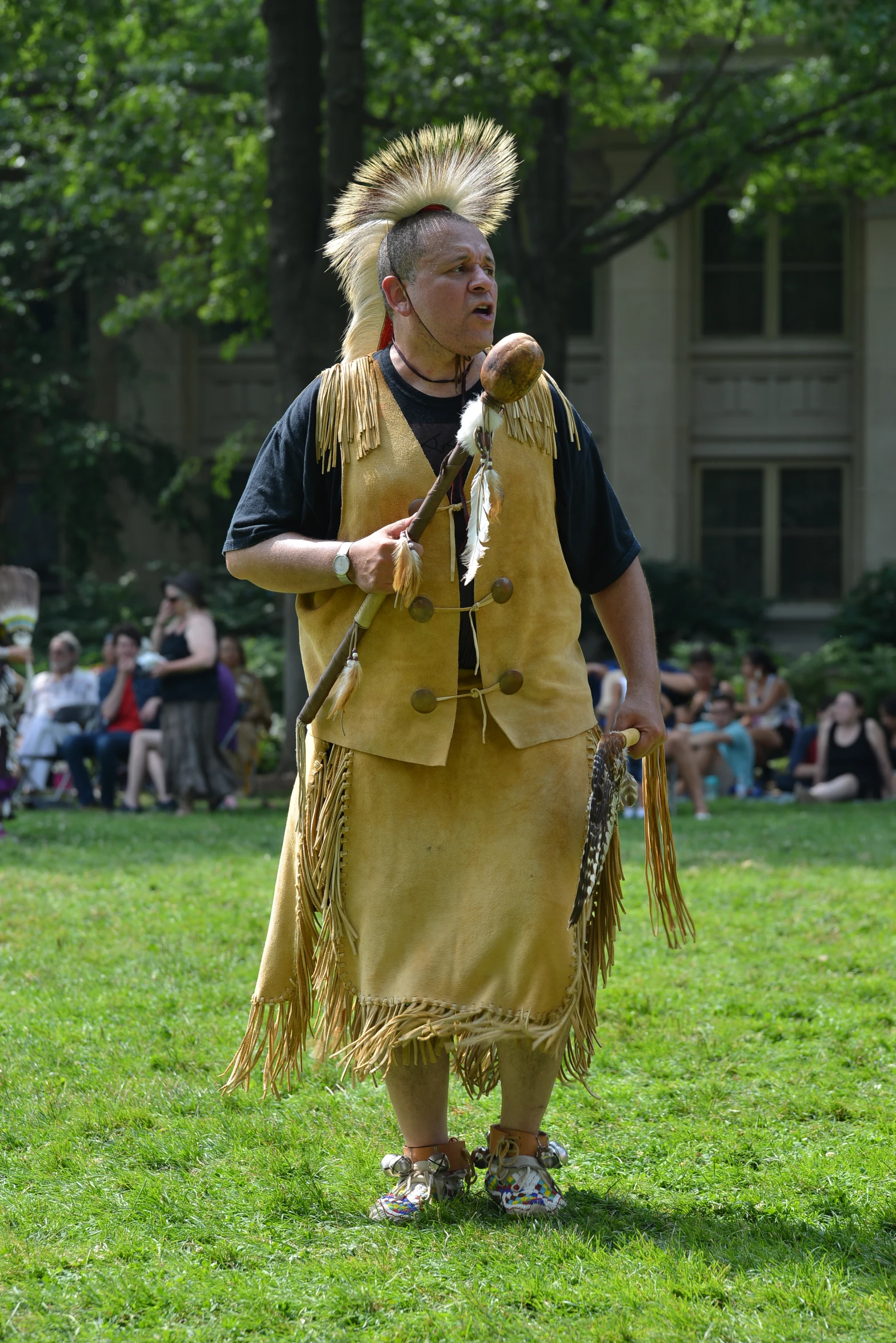 a native american woman in costume holding whip while looking at soing