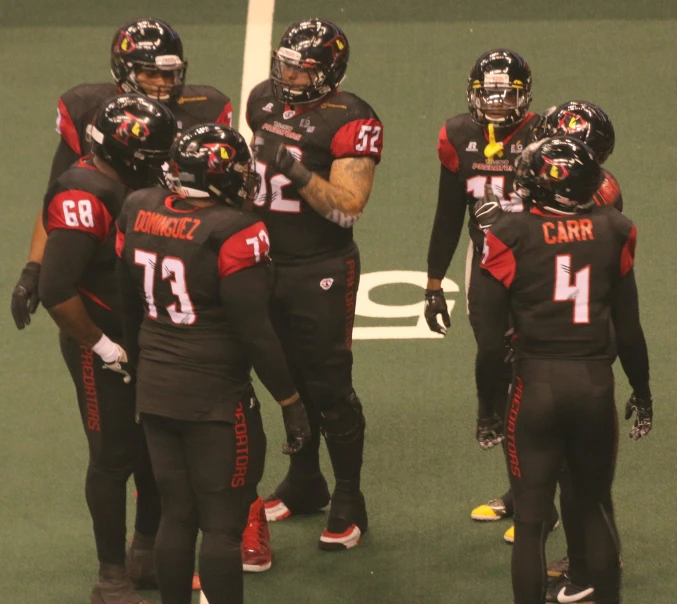 a group of football players standing on top of a field