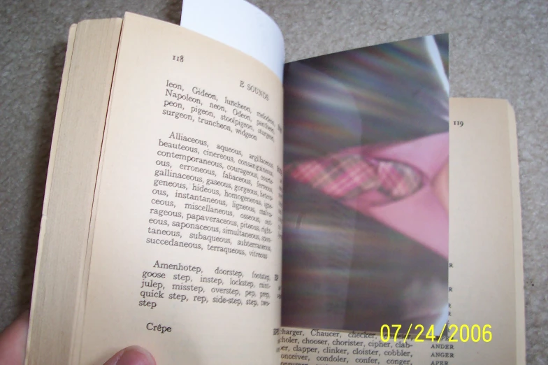a hand is opening a book with many page sections