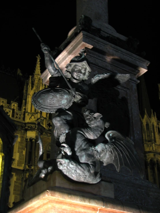 a clock tower with an angel statue in front of it