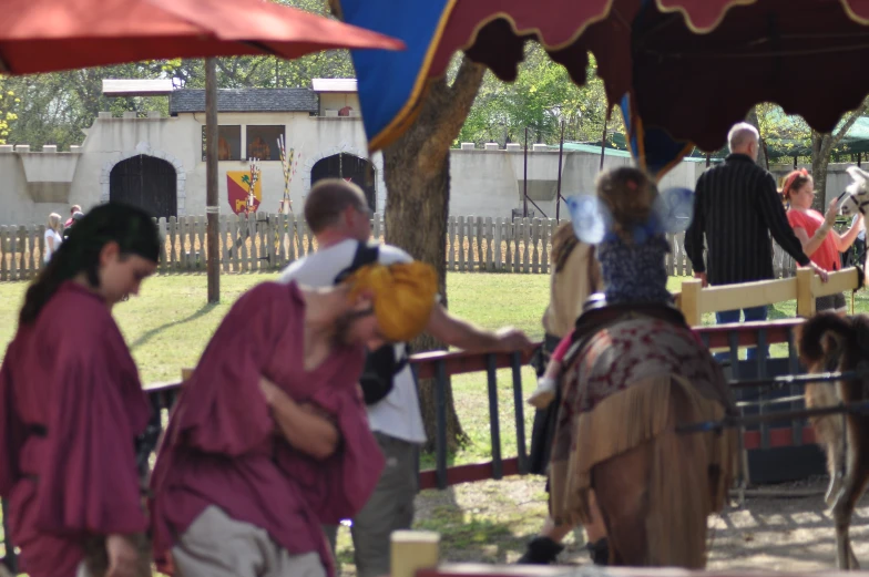 two people in purple outfits riding on a horse with a person dressed like a clown