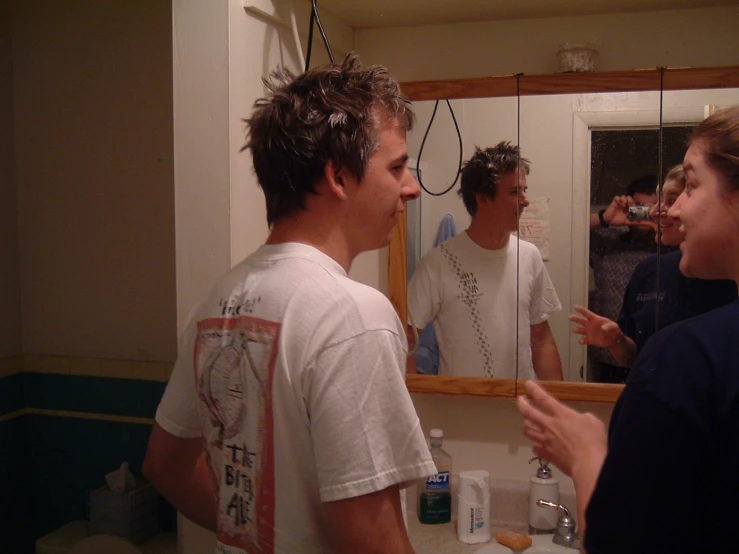 some guys in a bathroom brushing their teeth