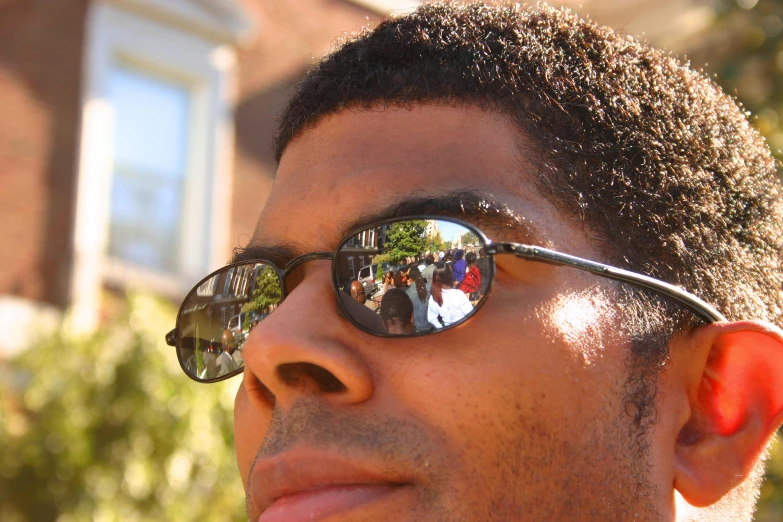 a man in sunglasses has his picture reflected on the lens