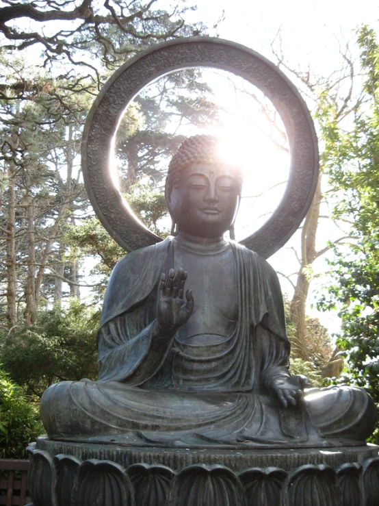 buddha statue sitting in the middle of a garden