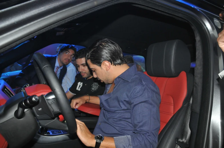 a man sitting at the steering wheel of a car