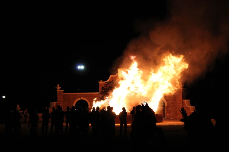 large group of people standing around a huge fire