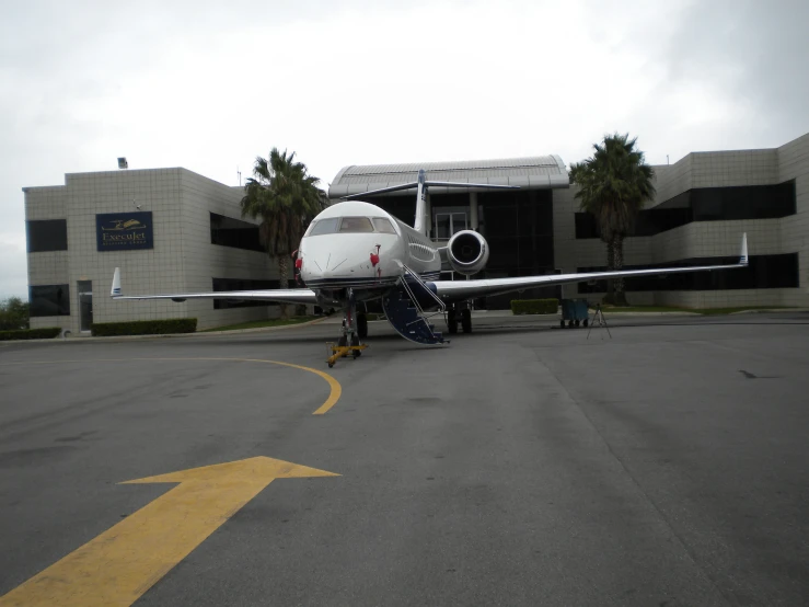 a white plane on the street with a man working near it