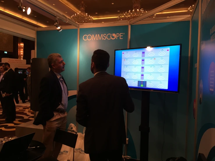 people standing in front of a tv with the word commscope