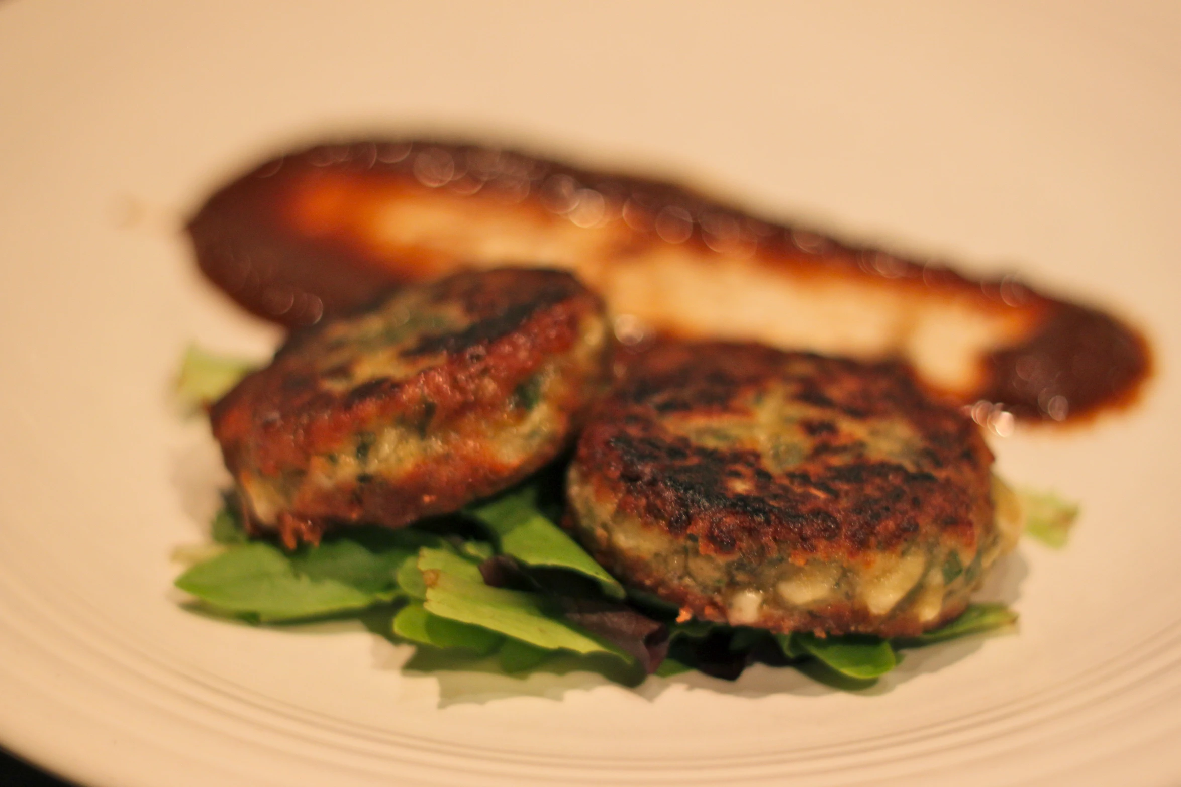 some meat patties with lettuce on a white plate