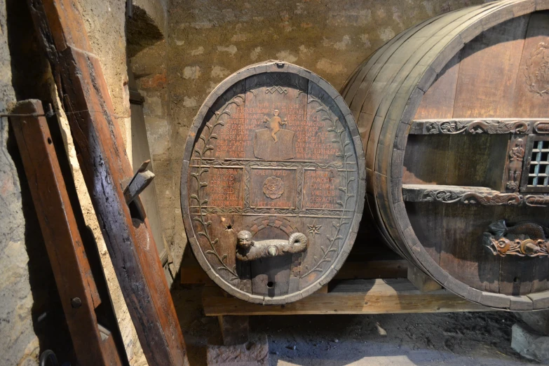 two wooden wine barrels sit on display in a wine store