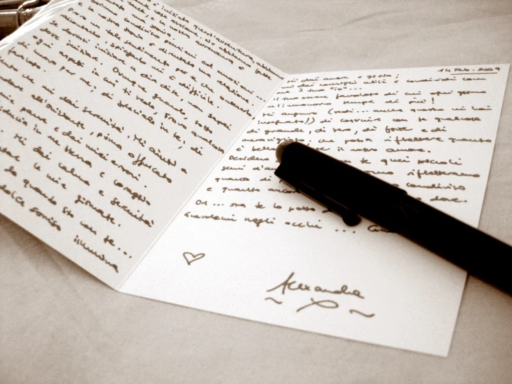 a pen on top of a notebook with writing