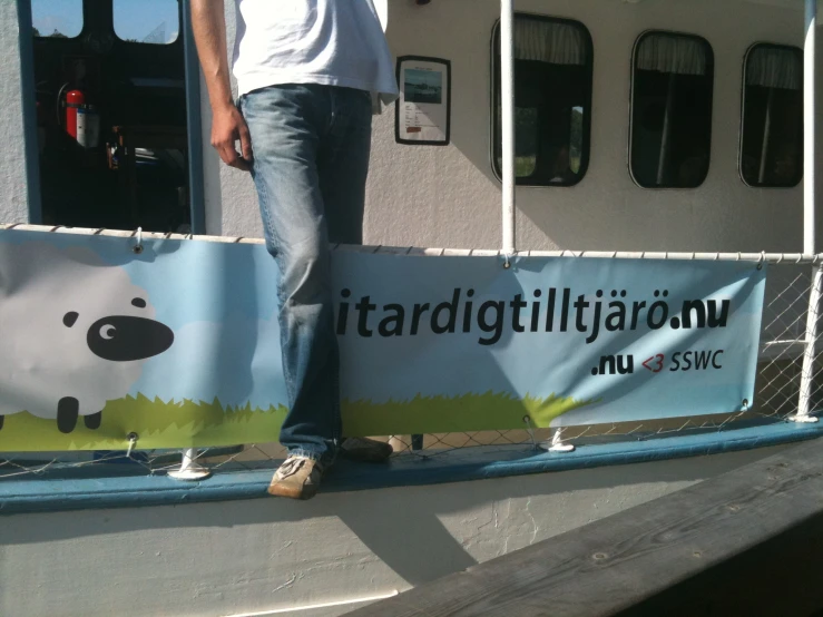 a man standing on the back of a boat, holding onto a banner