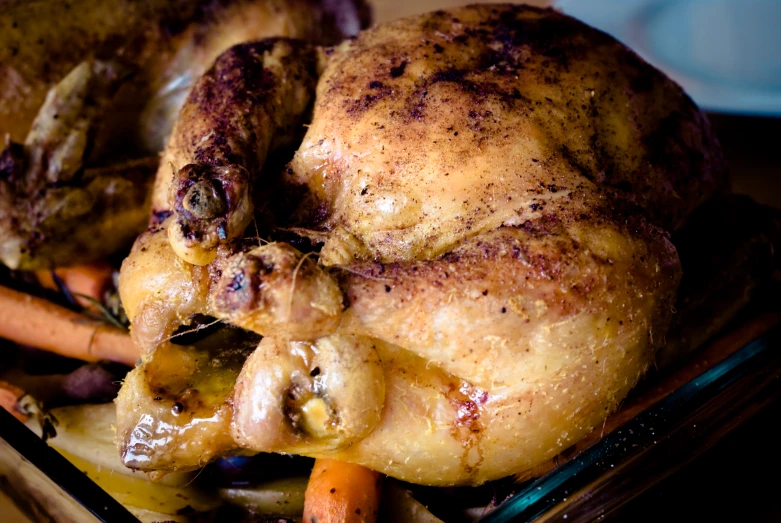 a large chicken with carrots and a garlic