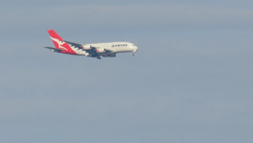 a white and red airplane in a blue sky