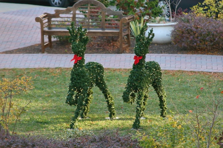 pair of outdoor sculptures in the grass decorated with vines