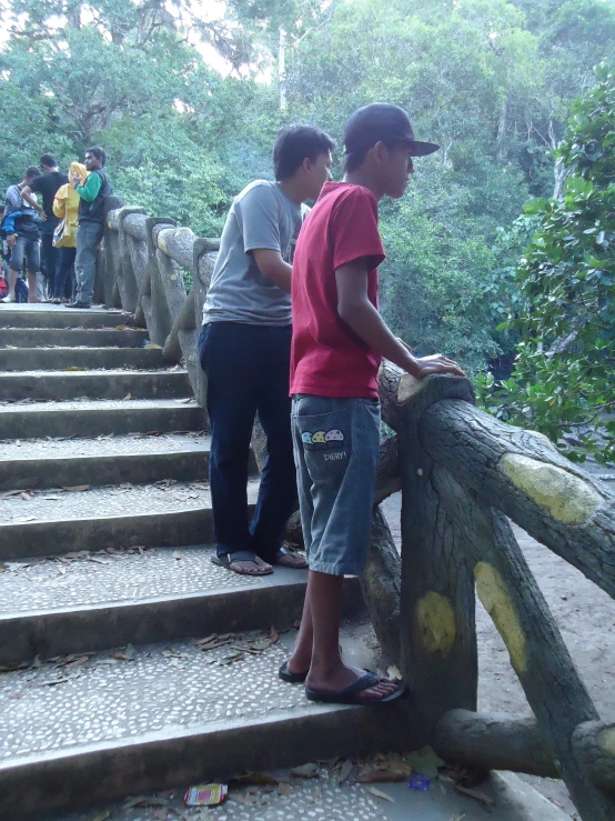 there are three boys that are climbing a wooden bridge