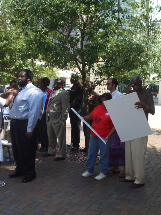 a man holding a paper while people wait in line