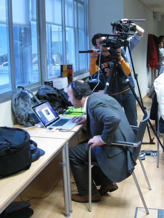 two men standing in front of a table with cameras