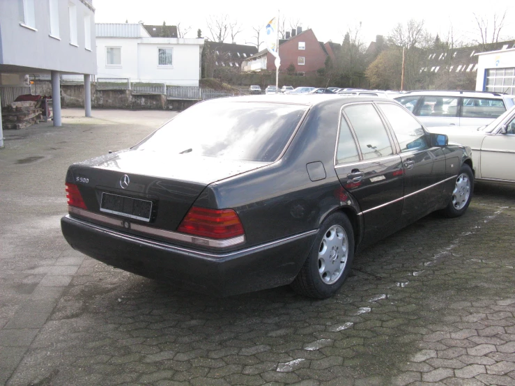 a black mercedes is parked in front of other cars