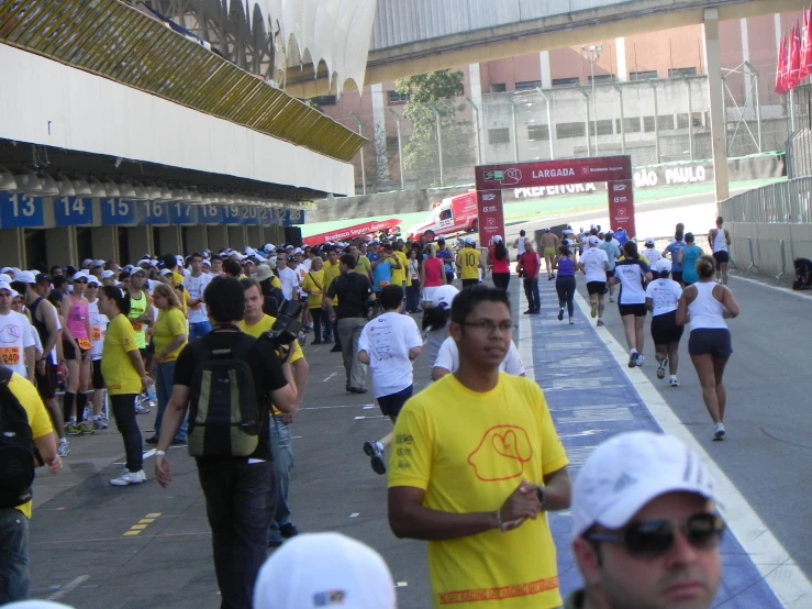 many people in yellow shirts are on a race track