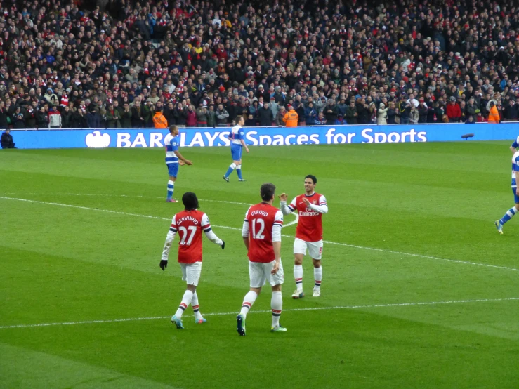 players in uniforms playing soccer on a soccer field