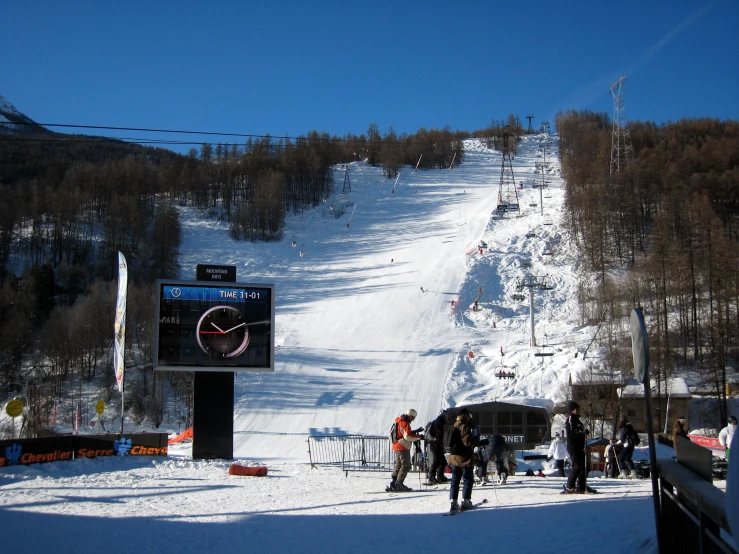 many people are skiing down the snowy slope