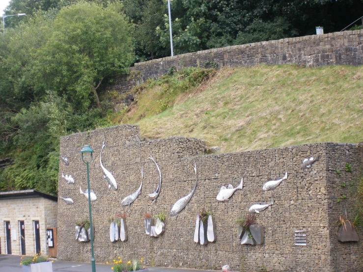 a stone wall with a bunch of bird feathers hanging on the side
