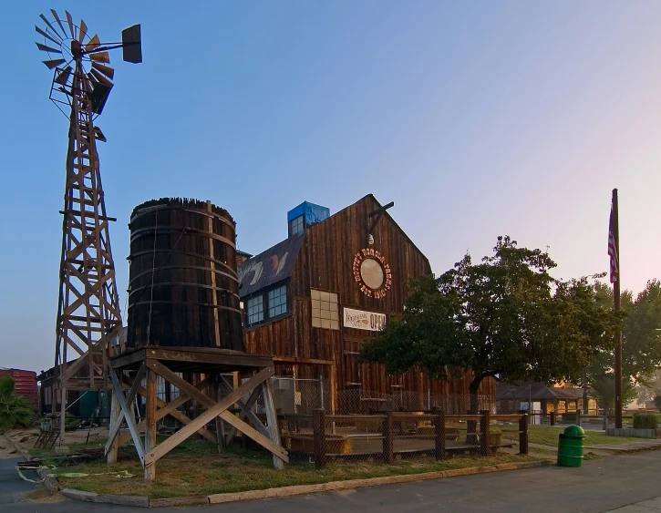 a tall windmill standing next to a wooden building