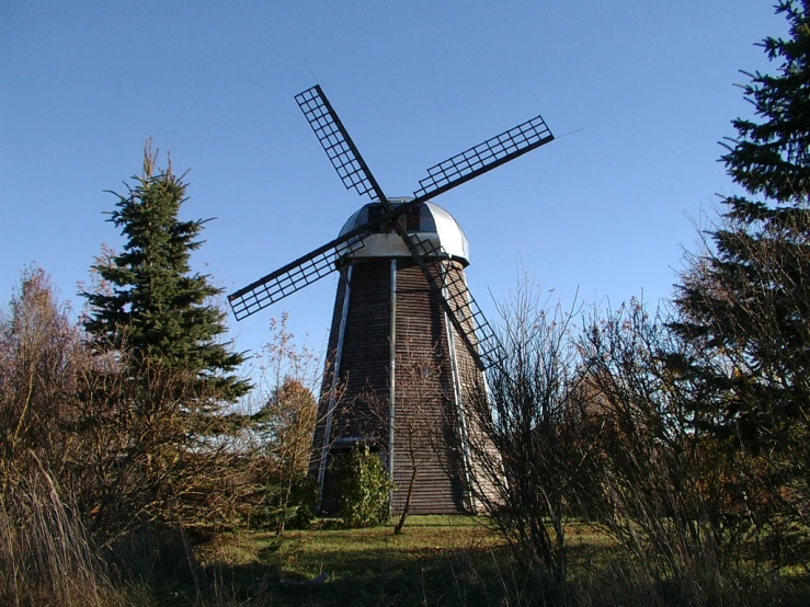 a mill sitting on a hillside between trees