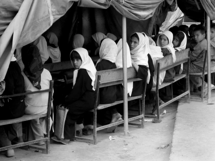 many women sitting next to each other in a shelter