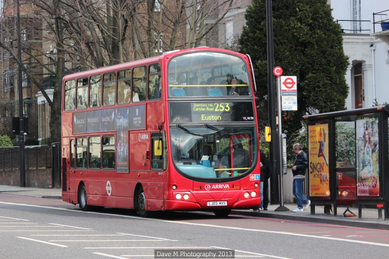 a red bus driving down the street near some buildings