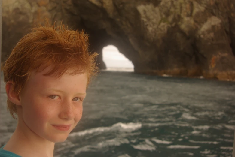 a boy on a boat looks out at the camera