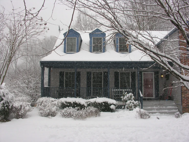 a snow covered yard with an old house and steps