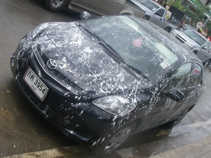 the front of a black car covered in plastic