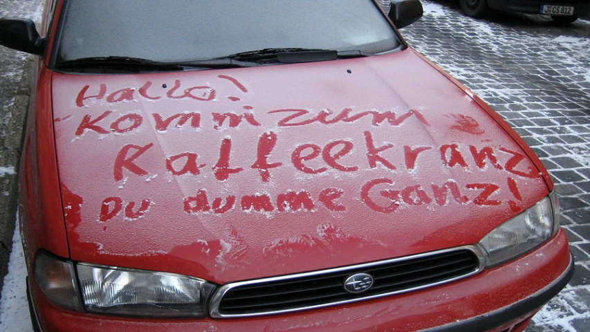 a red car with graffiti is shown in this picture