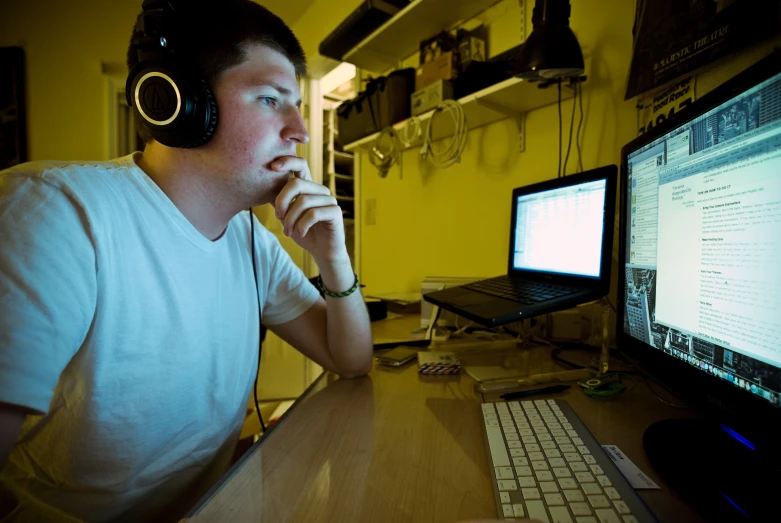 a man that is sitting in front of a monitor