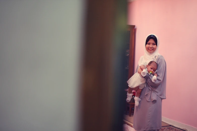 a woman with a baby standing in front of a doorway