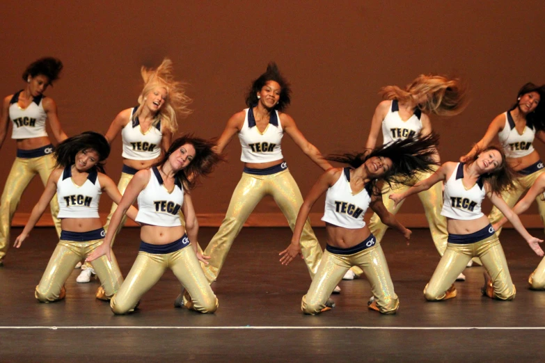 a group of s dressed in gold and white outfits