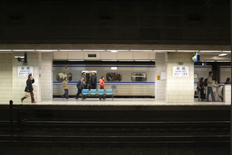 people walking in and out of the subway station at night