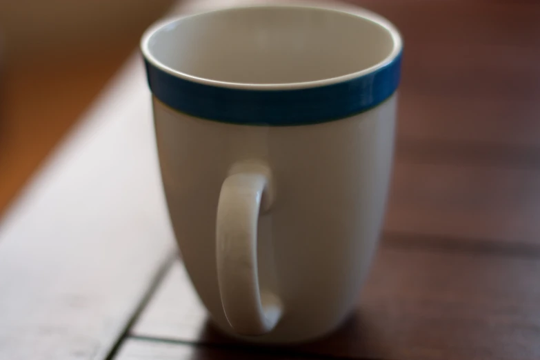 there is a small cup on the table with a blurry background