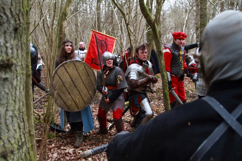 some knights in full medieval costumes are gathered around