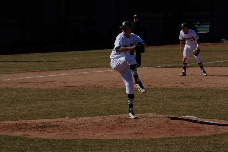 two baseball players on the field with one throwing a ball