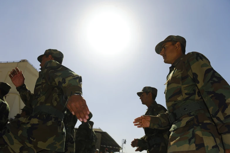 a group of soldiers are standing in the sun