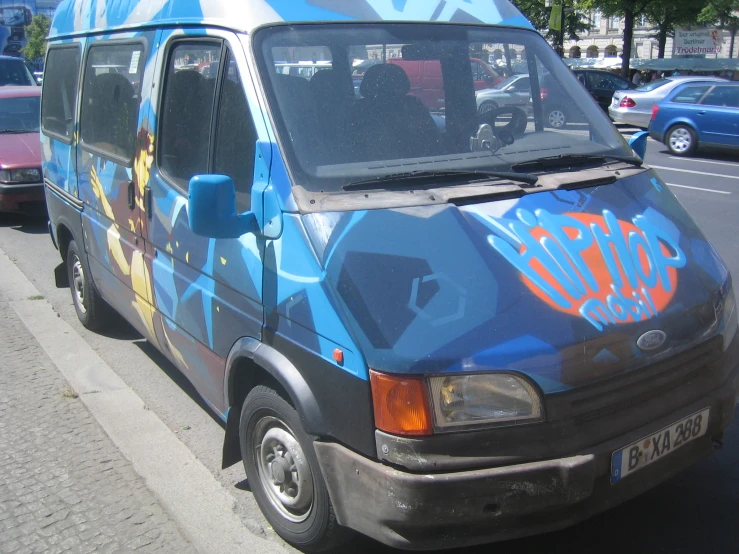 a blue and orange van with graffiti on the front of it