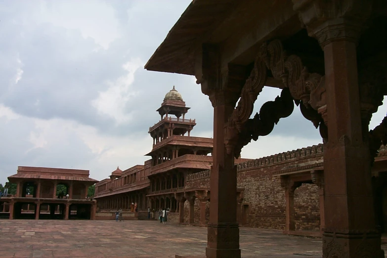 the building has pillars and towers in the courtyard