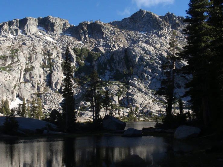 there is some mountain top with trees and rocks around it