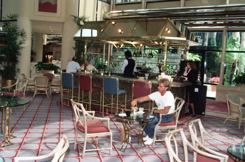 the interior of a building with tables, chairs and two bar