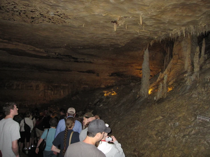 many people are looking up from an underground cave